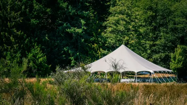 Large white event tent set up on a grassy field